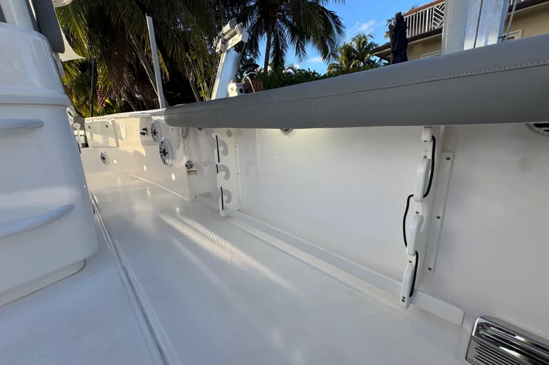 Slide: The Image of 2021 Everglades 335 Center Console boat docked by waterfront with palm trees and clear sky. - 10