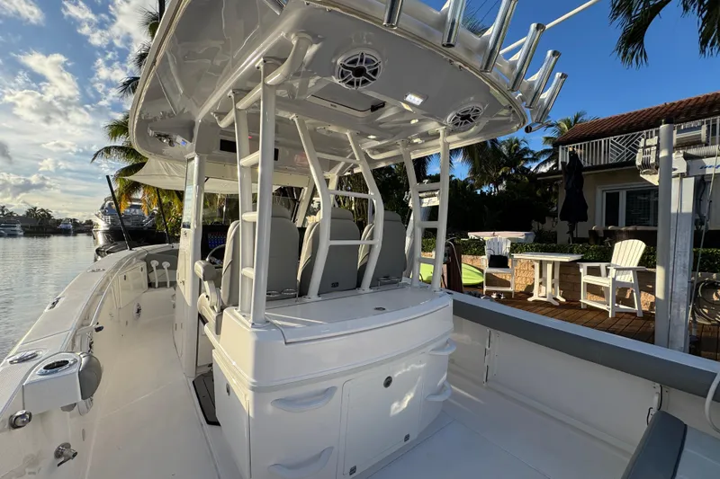 Slide: The Image of 2021 Everglades 335 Center Console boat with open storage compartment and cushioned seating. - 12