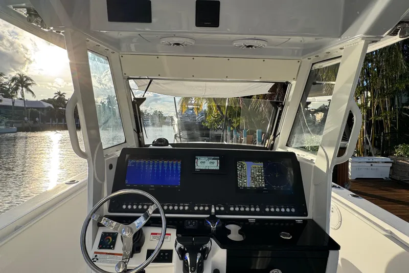 Slide: The Image of 2021 Everglades 335 Center Console boat docked by waterfront home, sunny day. - 16