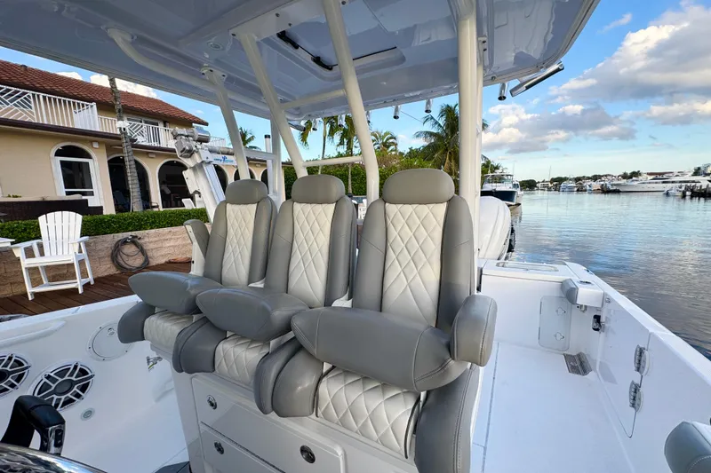 Slide: The Image of 2021 Everglades 335 Center Console boat with luxurious seating, docked by waterfront homes. - 18