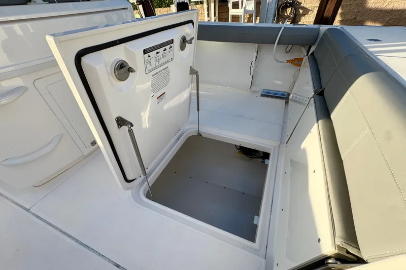 Slide: The Image of Open storage compartment on 2021 Everglades 335 Center Console boat, docked by water. - 8