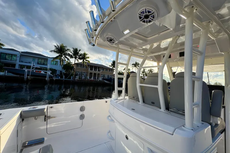 Slide: The Image of 2021 Everglades 335 Center Console boat with open storage compartment by the water. - 9