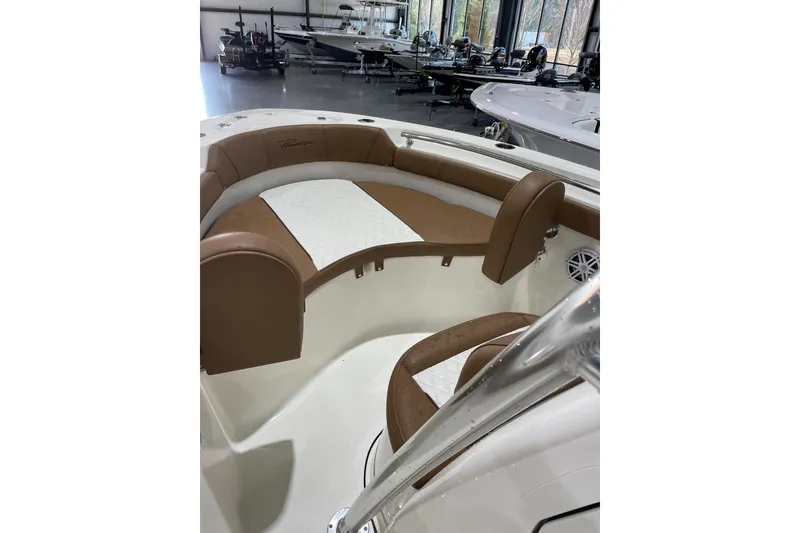 Slide: The Image of 2026 Pioneer 202 Islander boat interior with brown and white seating in showroom. - 6