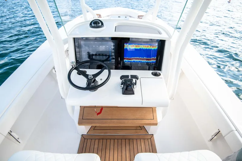 Slide: The Image of Manufacturer Provided Image: Cockpit of 2026 Jupiter 32 boat with steering wheel and navigation screens. - 4