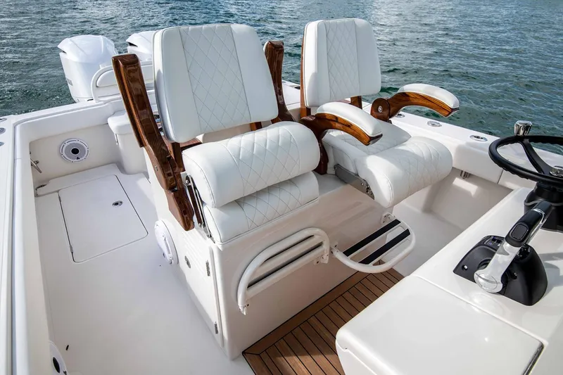 Slide: The Image of Manufacturer Provided Image: Luxurious seating on a 2026 Jupiter 32 boat with elegant white upholstery and wooden accents. - 5