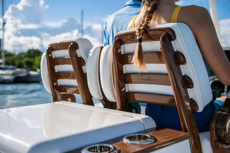 Slide: The Image of Manufacturer Provided Image: Luxury seating on a 2026 Jupiter 32 boat, featuring wooden accents and cup holders. - 6