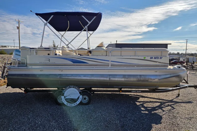 Slide: The Image of 2003 Bennington 2275LX pontoon boat with canopy on trailer, parked outdoors. - 2