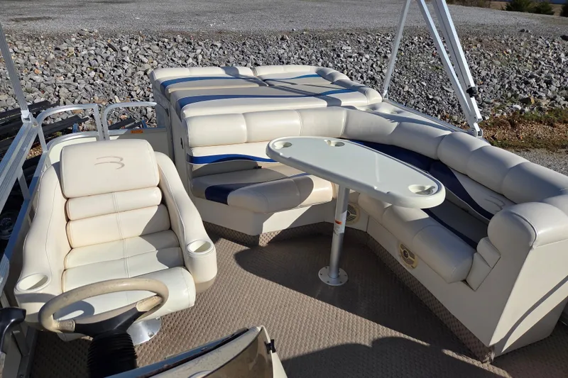 Slide: The Image of 2003 Bennington 2275LX pontoon boat interior with plush seating and table. - 8