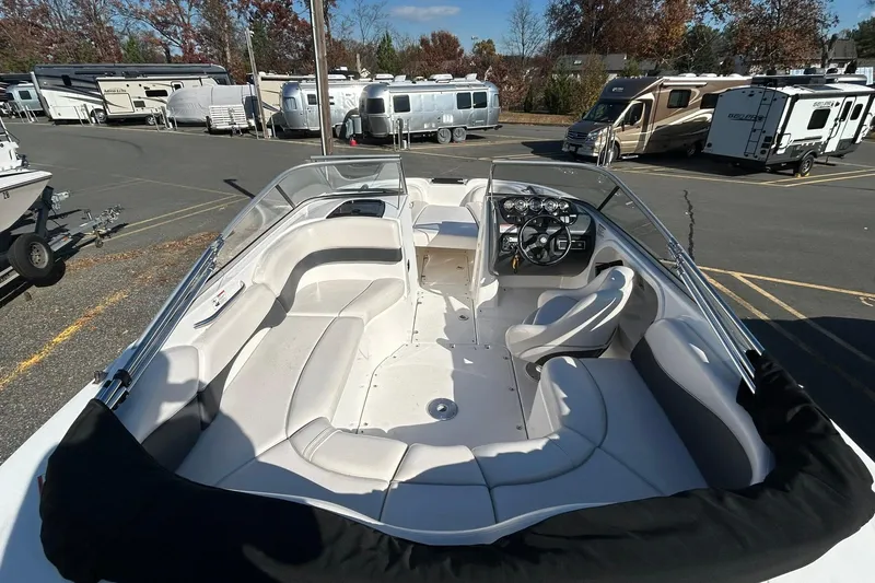 Slide: The Image of 2006 Yamaha Boats SX210 interior with seating and dashboard, parked near RVs and trailers. - 5