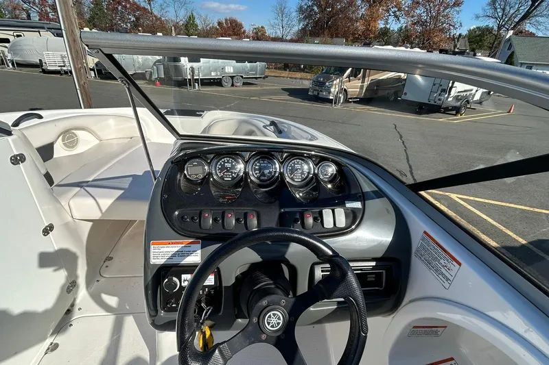 Slide: The Image of 2006 Yamaha Boats SX210 dashboard with steering wheel and gauges in a parking lot. - 8