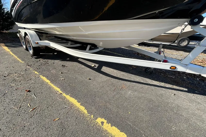 Slide: The Image of 2006 Yamaha Boats SX210 on trailer, parked on asphalt with yellow lines. - 9
