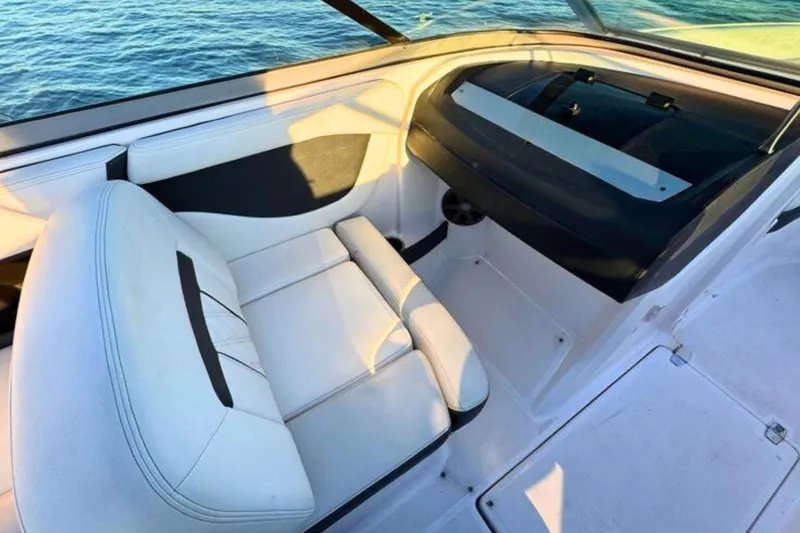 Slide: The Image of Interior of 2018 Regal 21 OBX boat with white seating and dashboard, near water. - 11