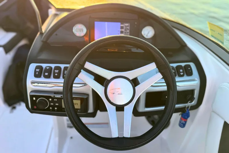 Slide: The Image of Steering wheel and dashboard of 2018 Regal 21 OBX boat at sunset. - 14