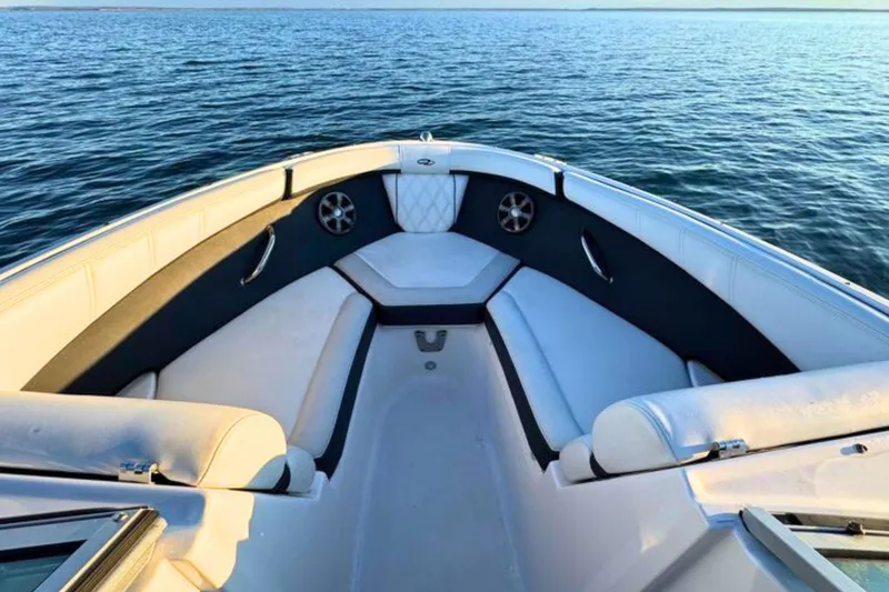 Slide: The Image of 2018 Regal 21 OBX boat interior with white seating on calm water. - 17