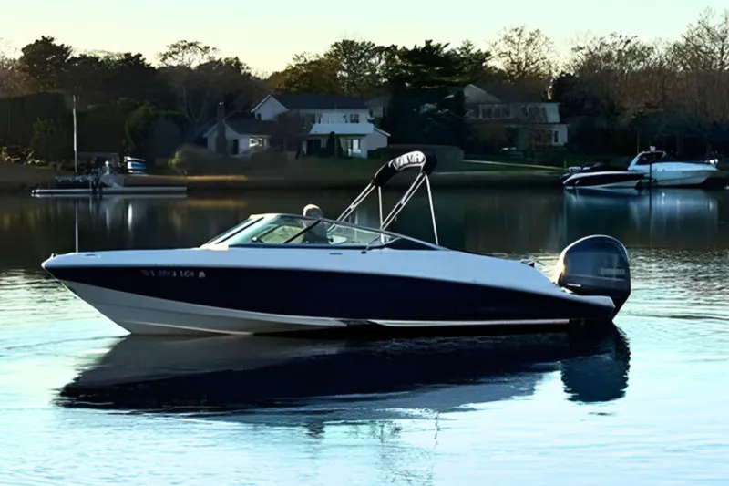 Slide: The Image of 2018 Regal 21 OBX boat on calm water near residential area. - 3