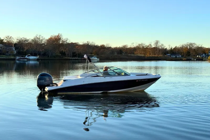 Slide: The Image of 2018 Regal 21 OBX boat on calm water with scenic background. - 5