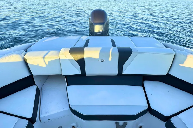 Slide: The Image of 2018 Regal 21 OBX boat interior with cushioned seating and outboard motor on water. - 8