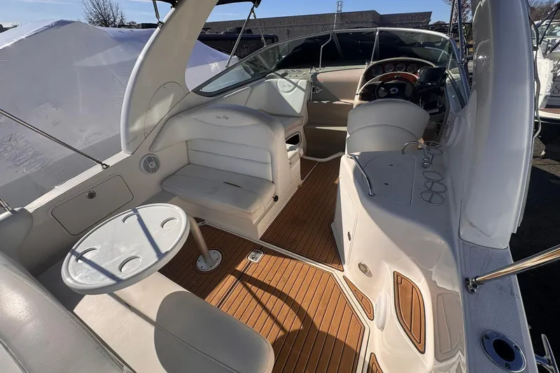 Slide: The Image of 2007 Sea Ray 280 Sundancer interior with seating, table, and helm, featuring wood flooring. - 11