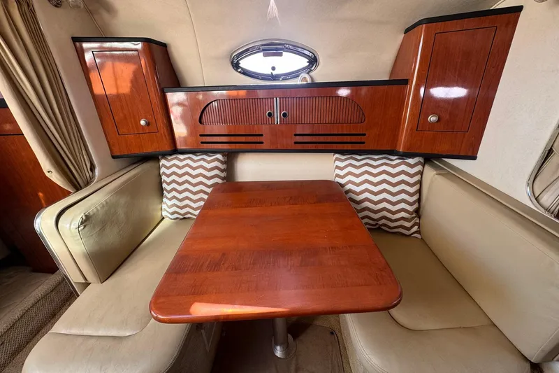 Slide: The Image of Interior of 2007 Sea Ray 280 Sundancer with wood table and cushioned seating. - 17