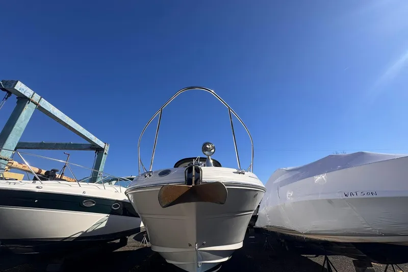Slide: The Image of 2007 Sea Ray 280 Sundancer boat in storage, surrounded by other vessels under clear blue sky. - 7