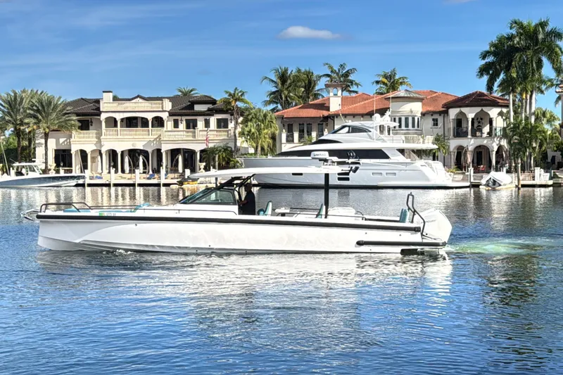 The Image of 2021 Axopar 37 Sun Top boat cruising near luxury waterfront homes. - 0
