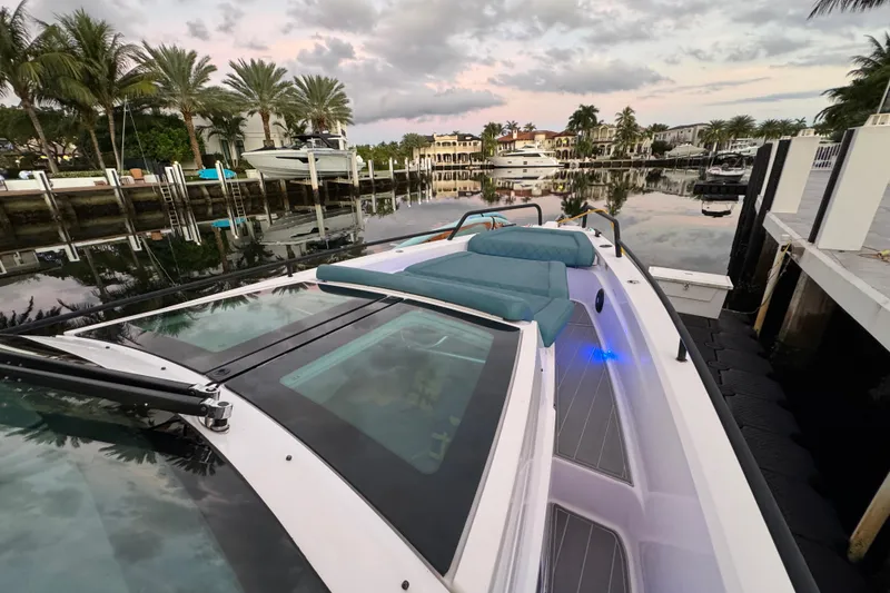 Slide: The Image of 2021 Axopar 37 Sun Top boat docked in a scenic marina with palm trees. - 20