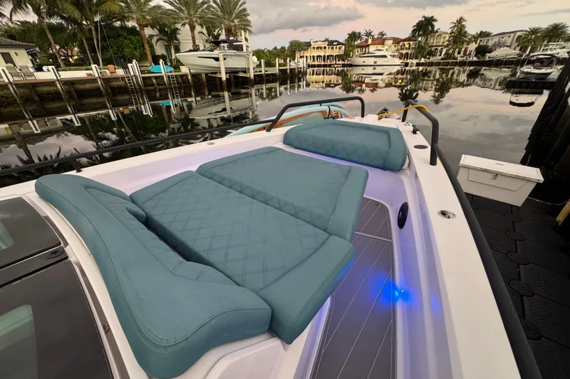 Slide: The Image of 2021 Axopar 37 boat with luxurious seating, docked near waterfront homes and palm trees. - 21