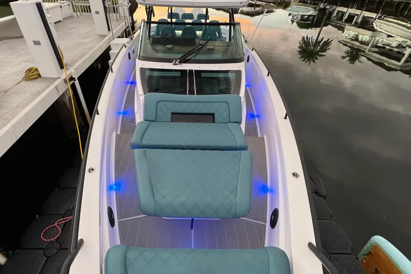 Slide: The Image of 2021 Axopar 37 Sun Top boat with blue LED lights and teal seating. - 24