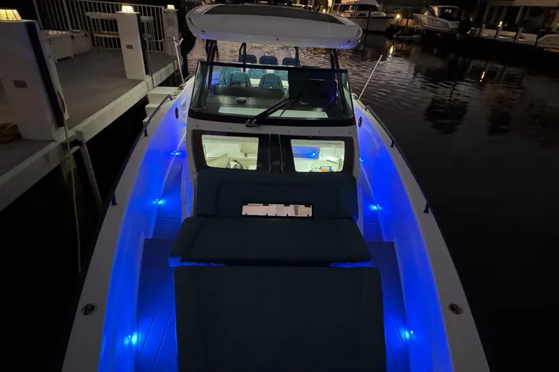 Slide: The Image of 2021 Axopar 37 boat with blue LED lights docked at night. - 26