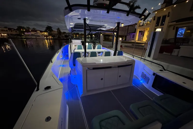 Slide: The Image of 2021 Axopar 37 boat with blue LED lights, docked at night. - 29