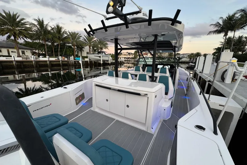 Slide: The Image of 2021 Axopar 37 Sun Top boat docked, featuring sleek design and modern seating. - 4