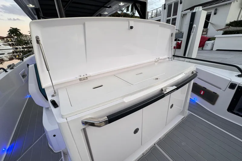 Slide: The Image of 2021 Axopar 37 Sun Top boat with open storage compartment on deck. - 5