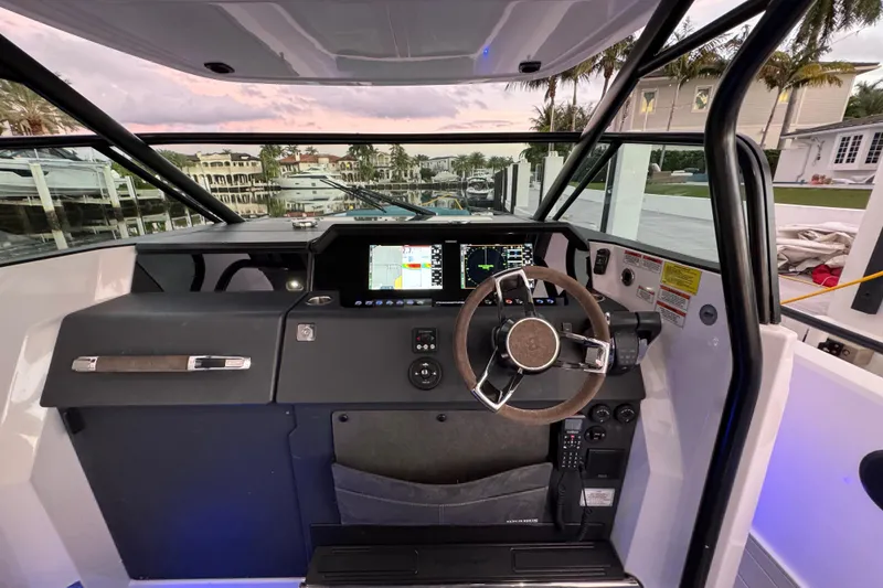 Slide: The Image of 2021 Axopar 37 boat cockpit with modern navigation system and steering wheel. - 9
