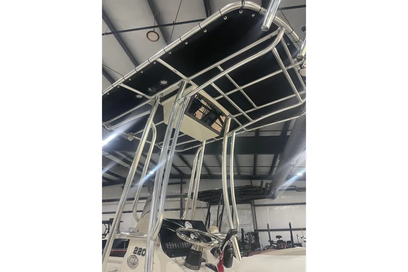 Slide: The Image of 2026 Bulls Bay 2200 XS boat with T-top and steering console in showroom. - 6