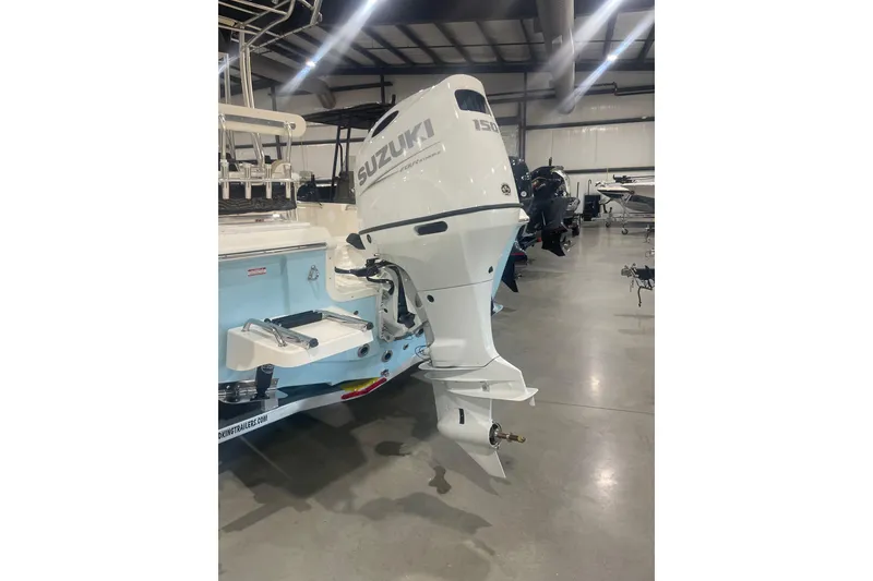 Slide: The Image of Bulls Bay 2200 XS 2026 boat with Suzuki outboard motor in a showroom. - 7