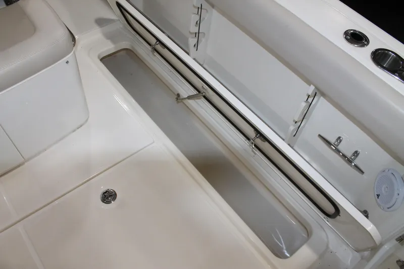Slide: The Image of 2017 Boston Whaler 330 Outrage interior storage compartment and seating area. - 32