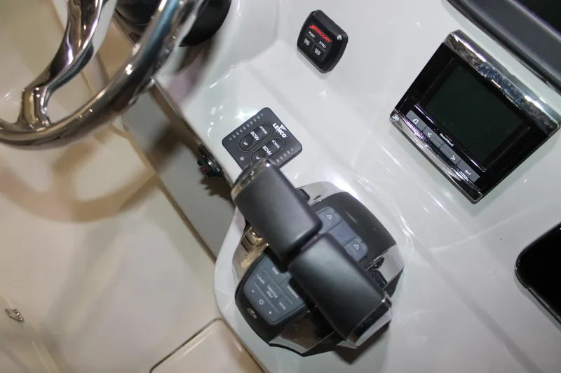 Slide: The Image of Control panel of a 2017 Boston Whaler 330 Outrage boat, featuring steering and electronic displays. - 46