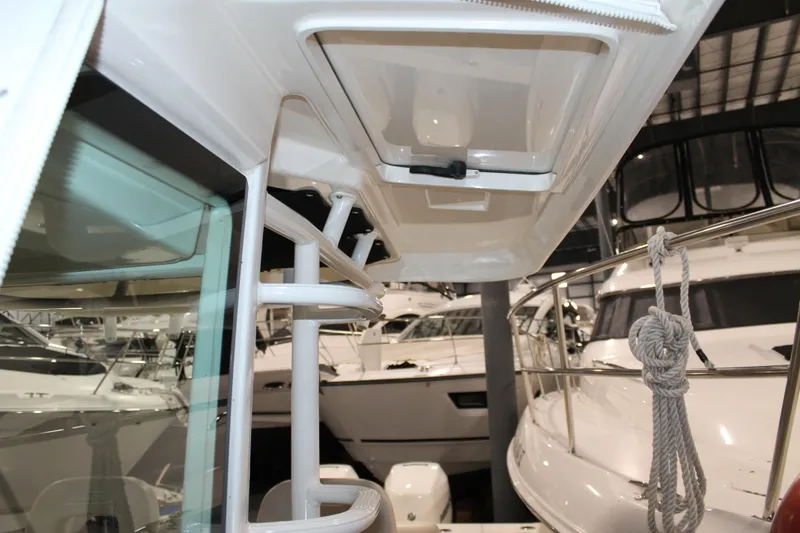 Slide: The Image of 2017 Boston Whaler 330 Outrage interior view with hatch and railing details. - 54