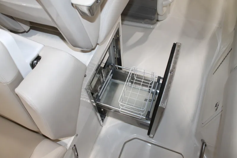 Slide: The Image of 2017 Boston Whaler 330 Outrage interior with open storage compartment and white seating. - 57