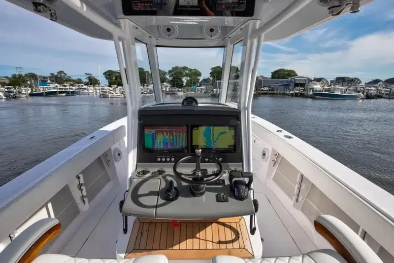 Slide: The Image of Manufacturer Provided Image: Helm of 2026 Jupiter 340LS boat with advanced navigation systems, docked at marina. - 2