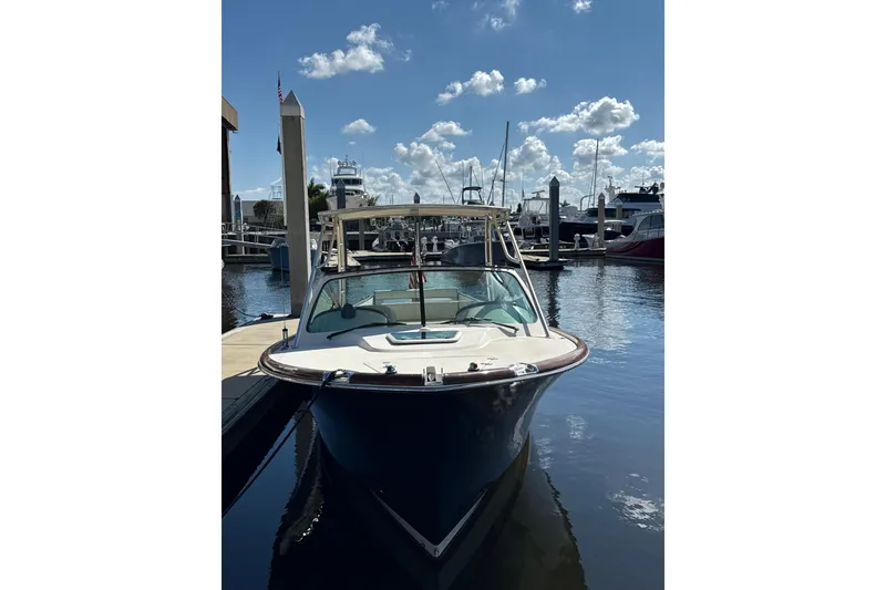 Slide: The Image of 2005 Hinckley Talaria 29 Runabout docked at a marina under a clear blue sky. - 2