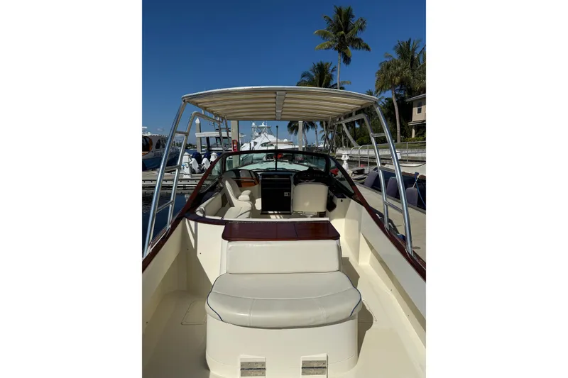 Slide: The Image of 2005 Hinckley Talaria 29 Runabout with canopy, docked under clear blue sky. - 6
