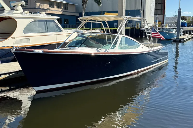 The Image of 2005 Hinckley Talaria 29 Runabout docked at marina, featuring sleek design and American flag. - 0