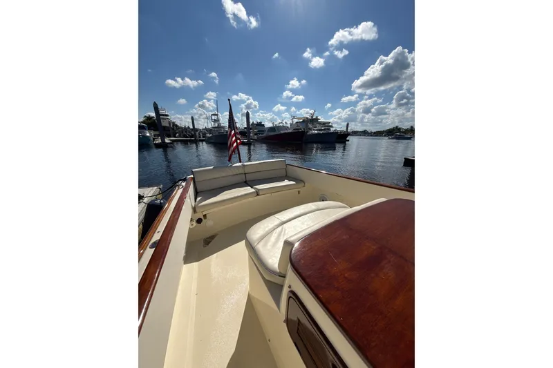 Slide: The Image of 2005 Hinckley Talaria 29 Runabout on calm waters, featuring elegant seating and a sunny sky. - 4