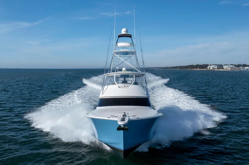 Slide: The Image of 2009 Viking 60 Convertible yacht cruising on open water, creating a dynamic wake. - 13