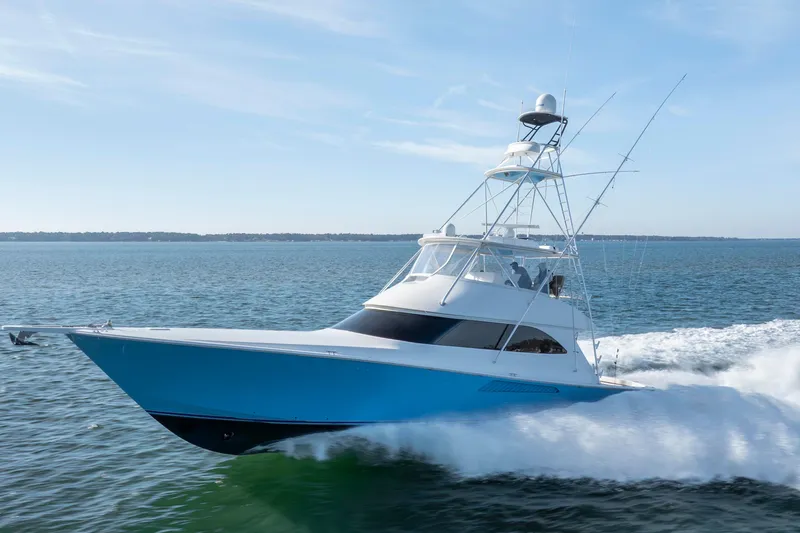 Slide: The Image of 2009 Viking 60 Convertible yacht cruising on open water under clear skies. - 14