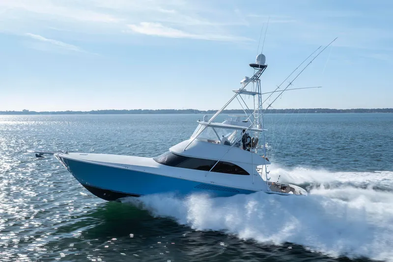 Slide: The Image of 2009 Viking 60 Convertible yacht cruising on open water, creating a dynamic wake. - 15