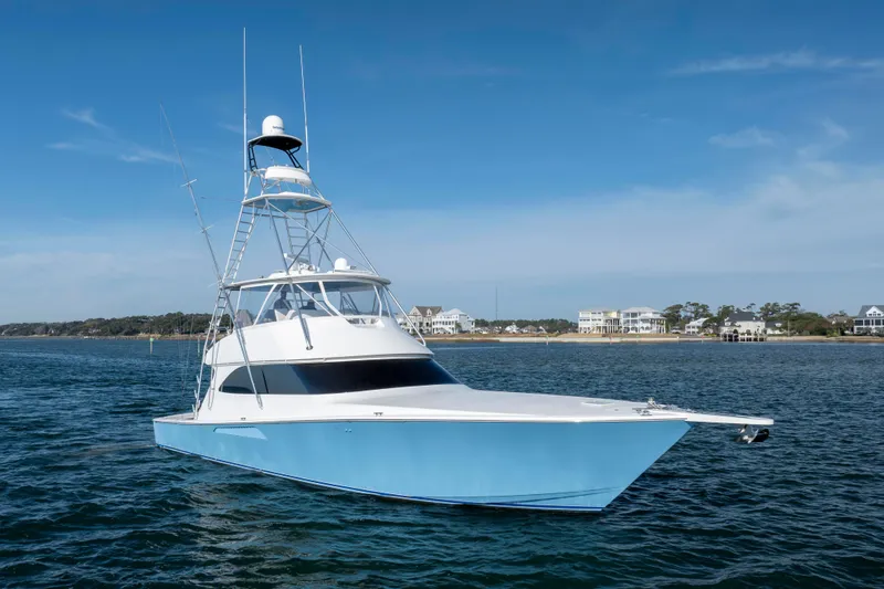 Slide: The Image of 2009 Viking 60 Convertible yacht on calm waters with coastal background. - 2