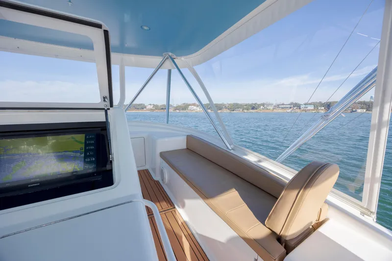 Slide: The Image of 2009 Viking 60 Convertible yacht interior with navigation display and seating, overlooking serene waters. - 55