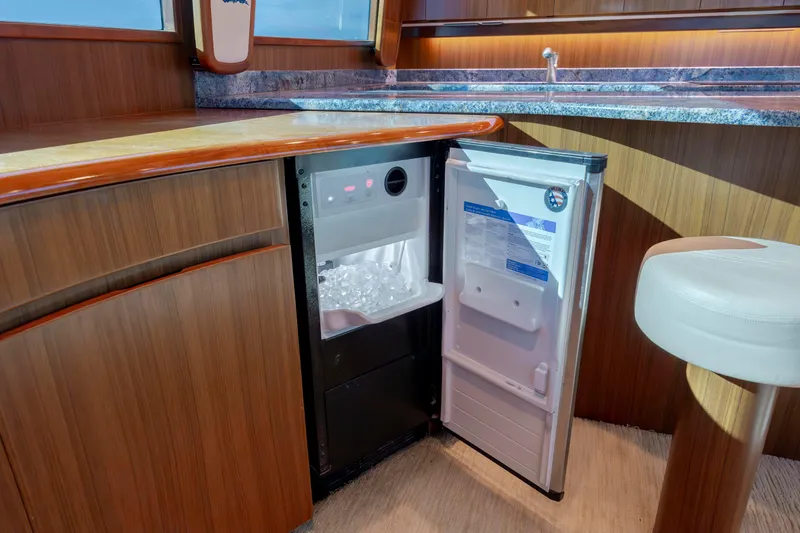 Slide: The Image of 2009 Viking 60 Convertible yacht interior with open ice maker, wooden cabinetry, and countertop. - 78
